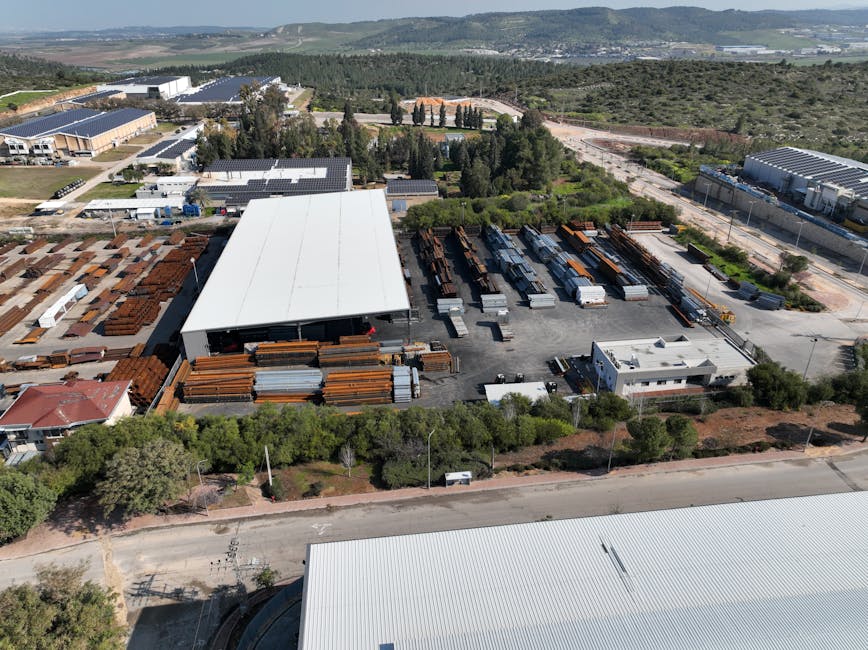 Aerial view of a large industrial facility with steel storage and warehouses.
