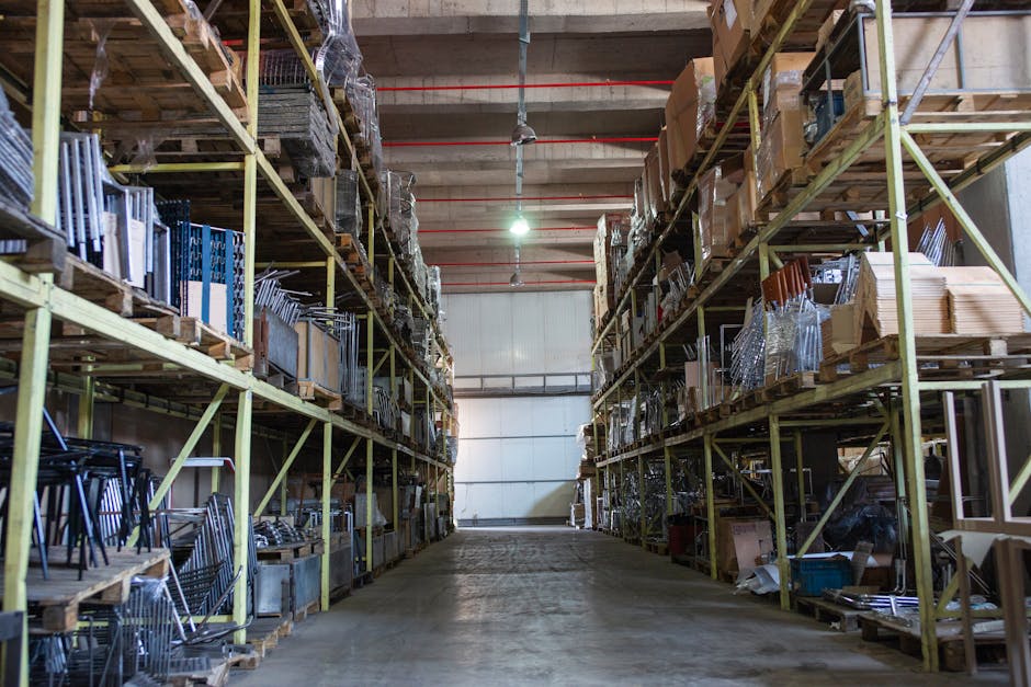 Wide aisle in a spacious warehouse filled with industrial metal shelving units.